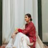 Pakistani girl in red and cream sharara sitting